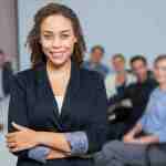 woman smiling with arms crossed colleagues out focus