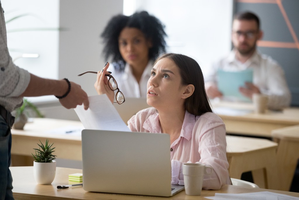 Employer Liability for Workplace Harassment 5 frustrated employee disagreeing receiving dismissal notice getting fired from job