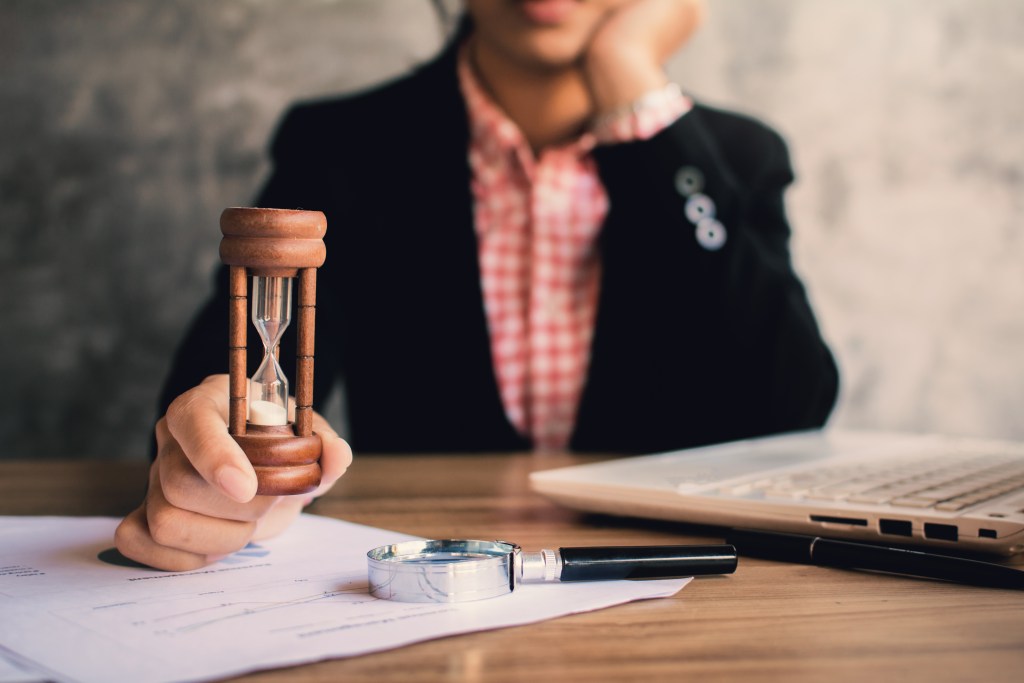 Time Limits for Filing Harassment Claims 8 midsection businesswoman with hourglass sitting office